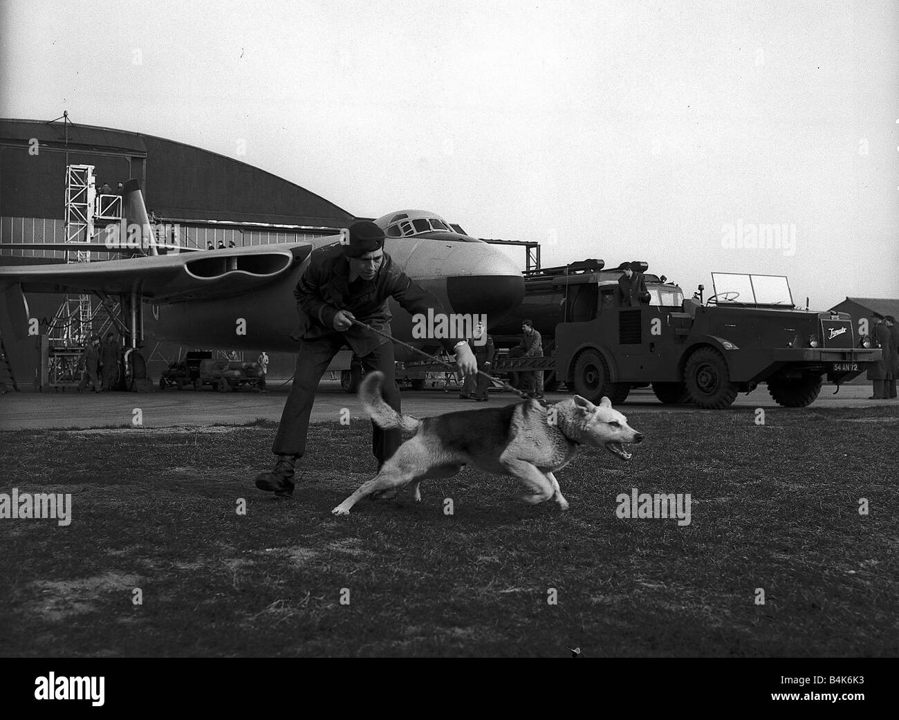Aeromobile Valliant Vickers V Bomber Marzo 1956 da RAF Marham in Norfolk un gestore del cane nella RAF polizia viene tirata dal suo ululano pastore tedesco Alsation cane da guardia LFEY003 Volo100 Foto Stock