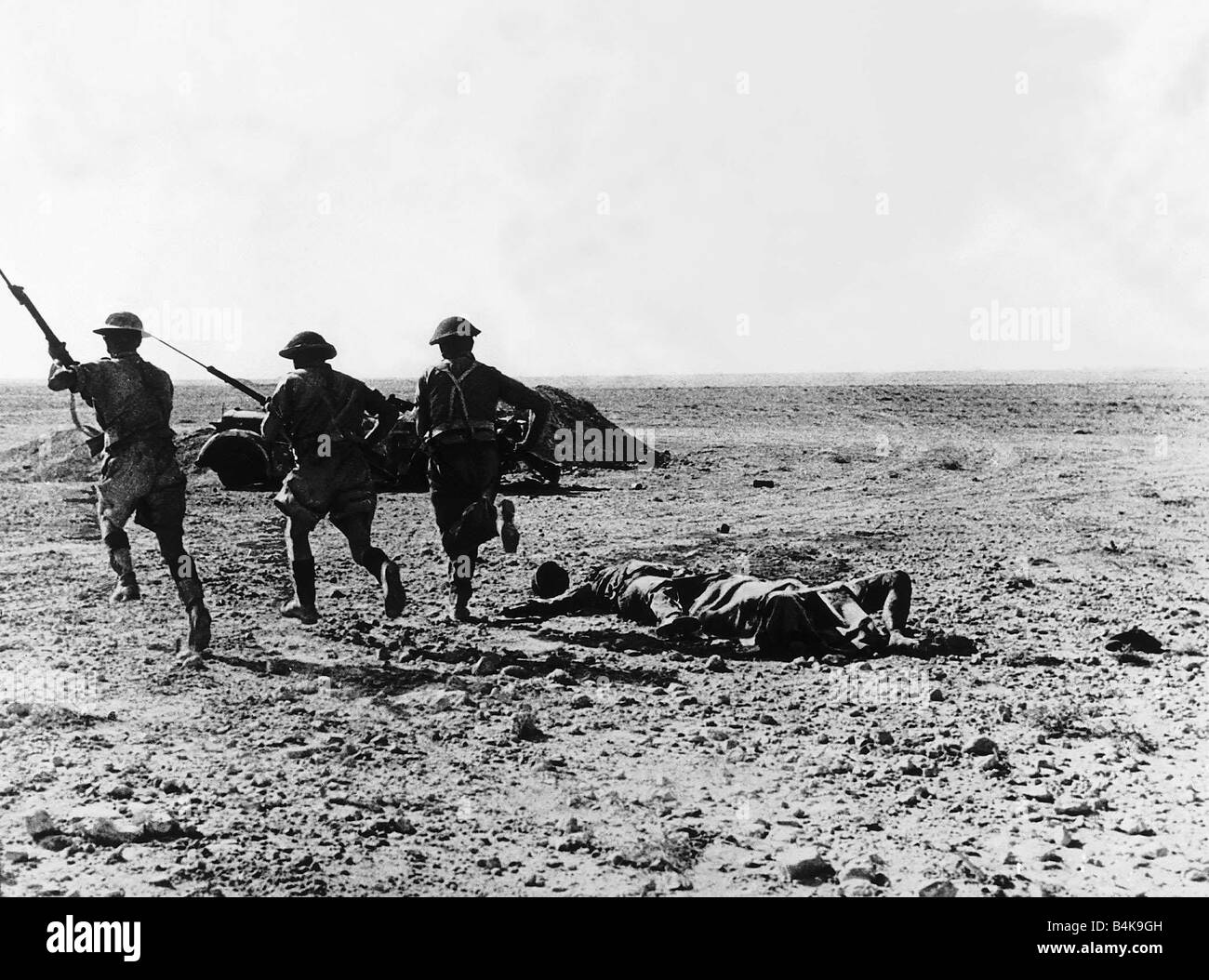 WW2 British fanti carica con baionette fissato a un nazista punto forte dietro di loro sono i corpi dei difensori tedesco Foto Stock