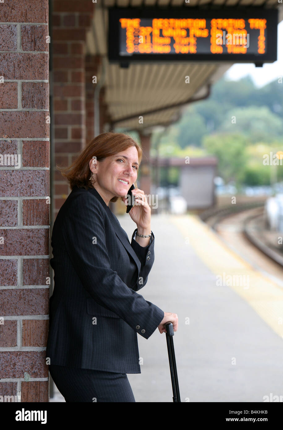 Il pendolarismo imprenditrice mantiene occupato mentre si attende l arrivo del suo treno Foto Stock