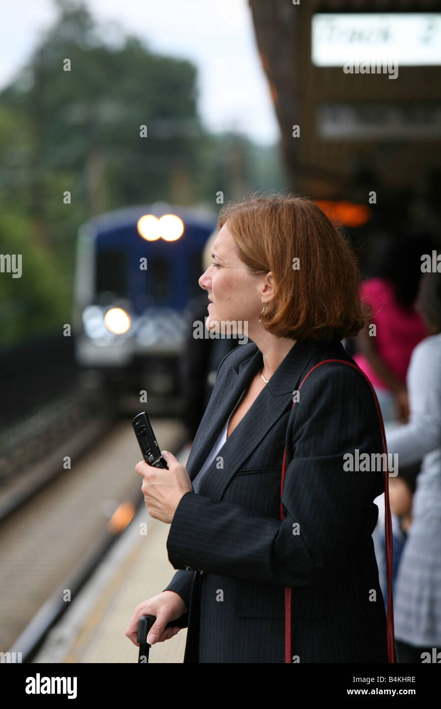 Il pendolarismo imprenditrice mantiene occupato mentre si attende l arrivo del suo treno Foto Stock