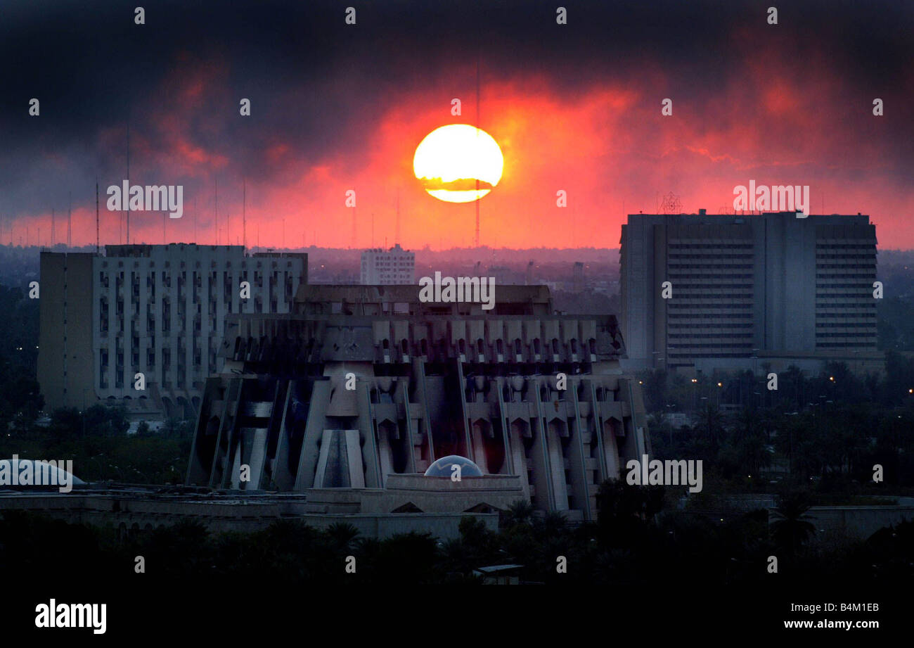 La guerra di Iraq Marzo 2003 Il set di sole attraverso la piena di fumo cielo sopra un bruciato a Bagdad dopo la allied attacchi aerei sulla città Foto Stock
