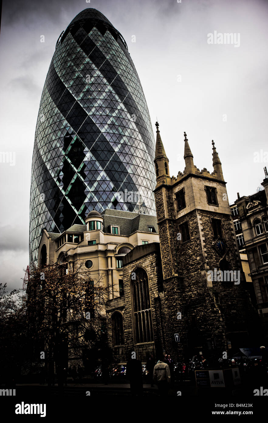 Il Gherkin, 30 St Mary Axe conosciuto anche come il Swiss Re edificio con la chiesa di St Andrew Undershaft in primo piano Foto Stock