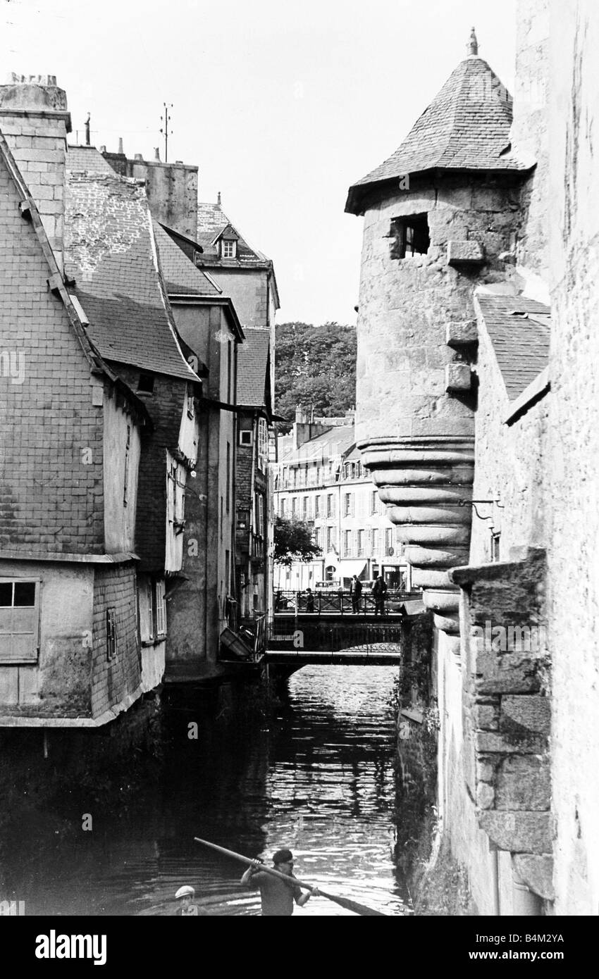 Bretagna Francia una scena in Bretagna vecchi bastioni e la vecchia casa di Quimper una vecchia città nel sud della Bretagna una barca è remare lungo il fiume attraverso le case Foto Stock