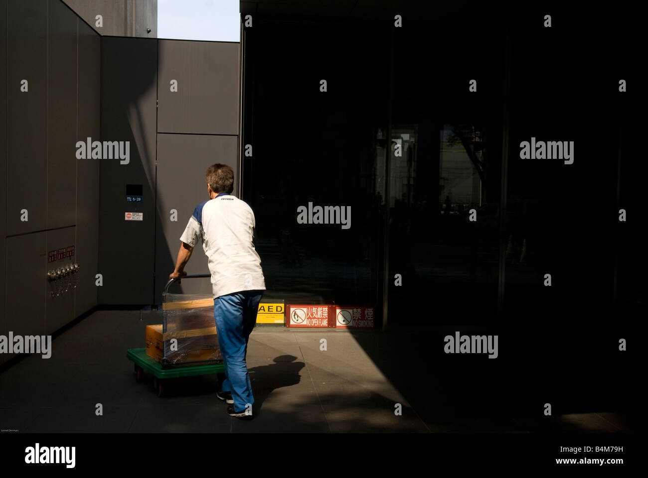 Consegna uomo spinge un carrello Foto Stock