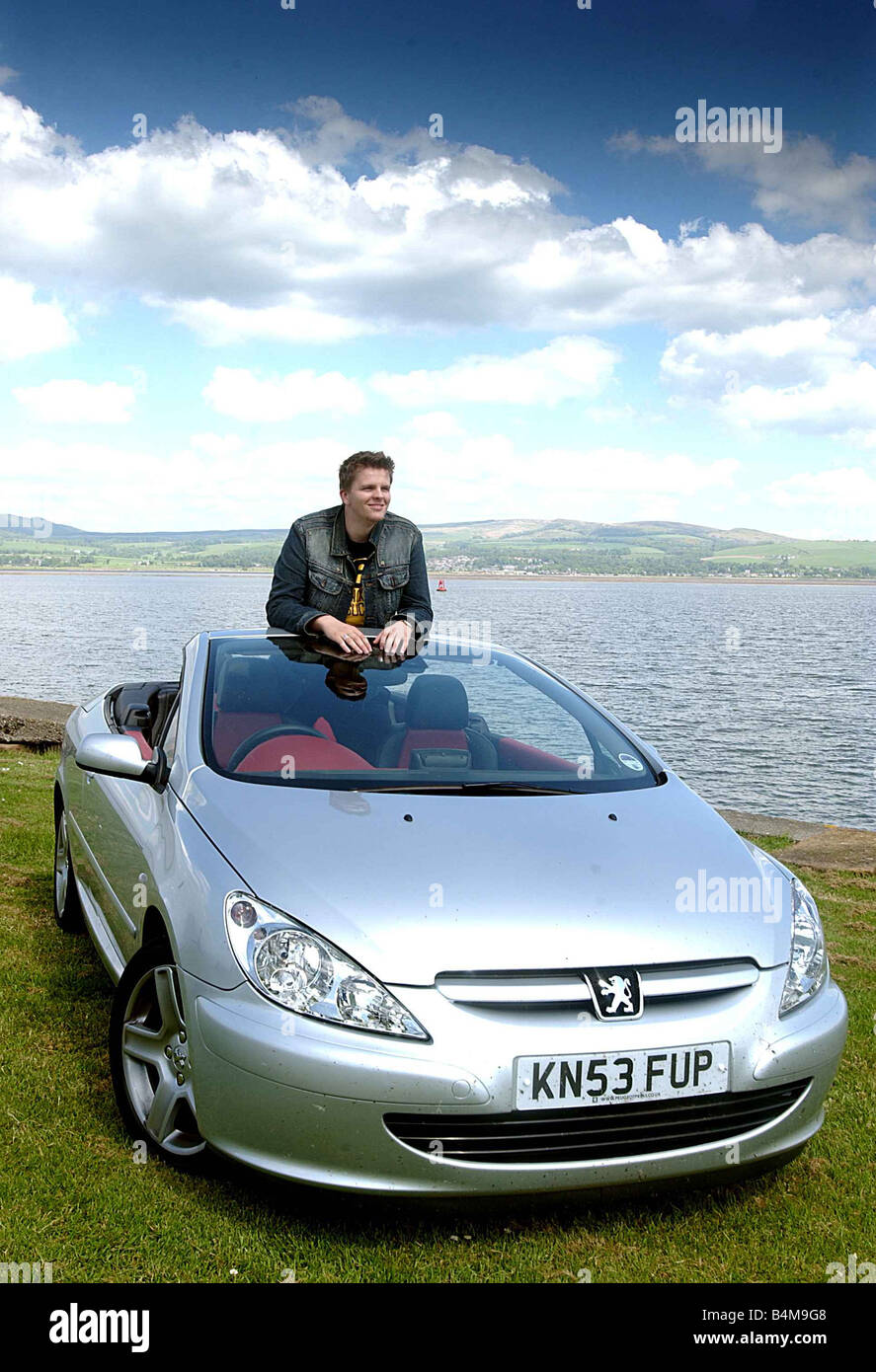 Jake Humphrey Giugno 2004 BBC TV per bambini Presenter con un Peugoet 307 Soft Top automobile Foto Stock