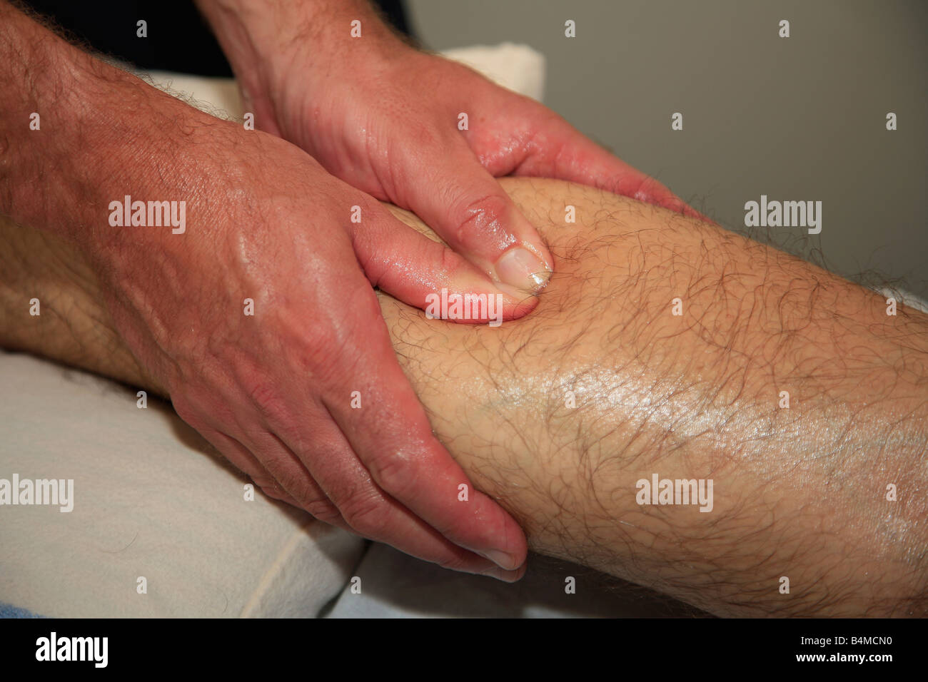 Sport FISIOTERAPIA Massaggio su un maschi feriti muscolo del polpaccio Foto Stock