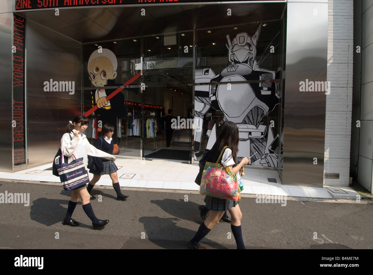 Studentesse passa davanti ad un manga shop in Tokyo. Foto Stock