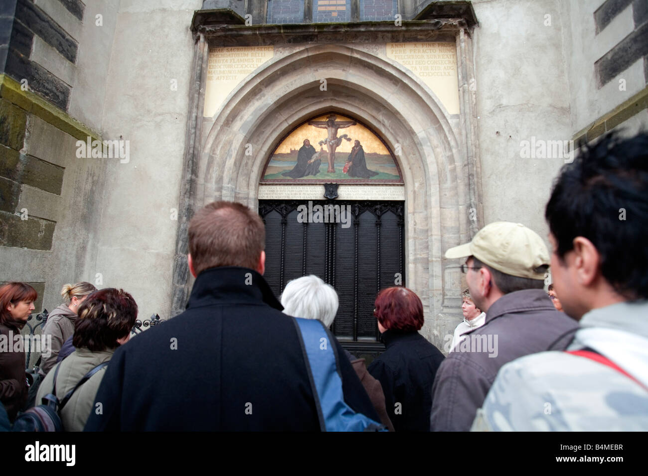 I turisti davanti alle porte del Schlosskirche in Wittenberg. Le porte sono decorate con Martin Lutero 95 tesi. Foto Stock