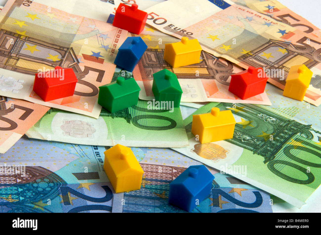 Case in miniatura sulle banconote in euro, immagine simbolica dei prezzi immobiliari in Europa Foto Stock