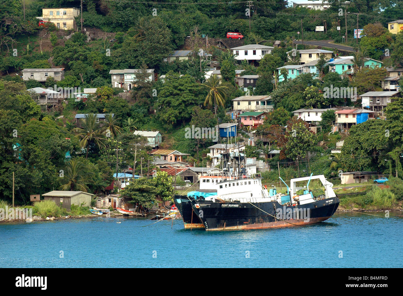 Litorale del porto di St Lucia mostra hillside residence e abbandonato il battello lungo la costa Foto Stock