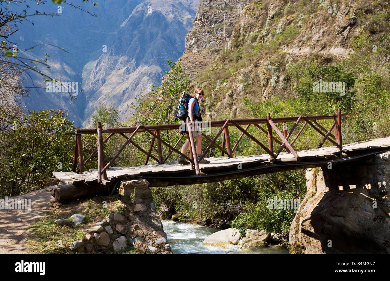 Trekker attraversamento passerella sul fiume Urubamba sul Cammino Inca attraverso le montagne delle Ande del Perù il primo giorno uno Foto Stock