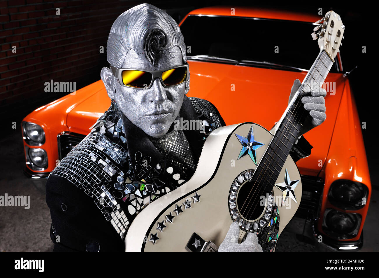 Licenza e stampe a MaximImages.com - Silver Elvis con una chitarra e una classica auto retrò americana Foto Stock