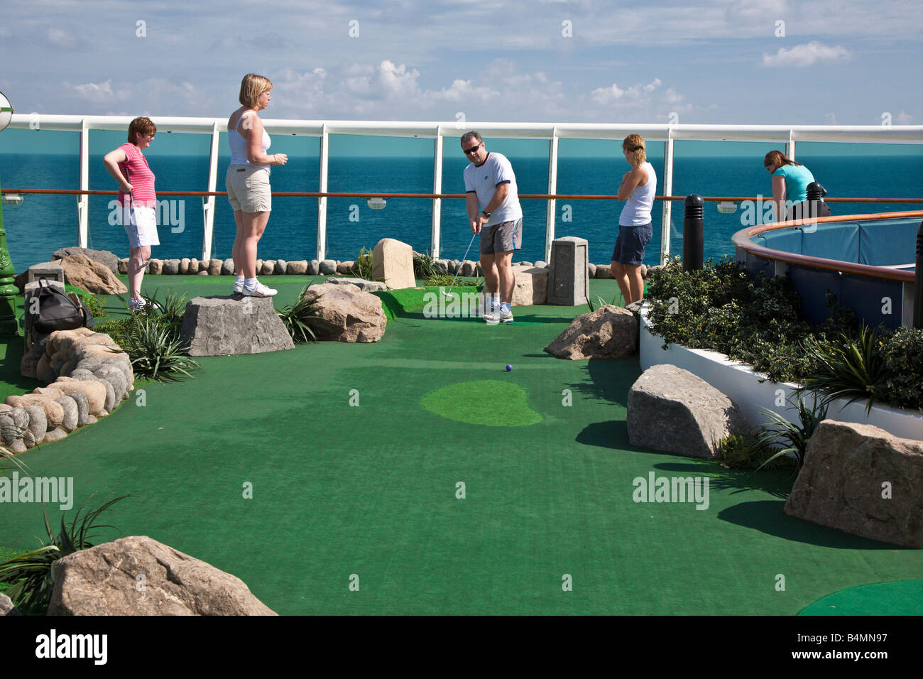 Gli ospiti delle crociere giocare a golf in miniatura sul ponte della Royal Caribbean Navigator dei mari nave da crociera Foto Stock