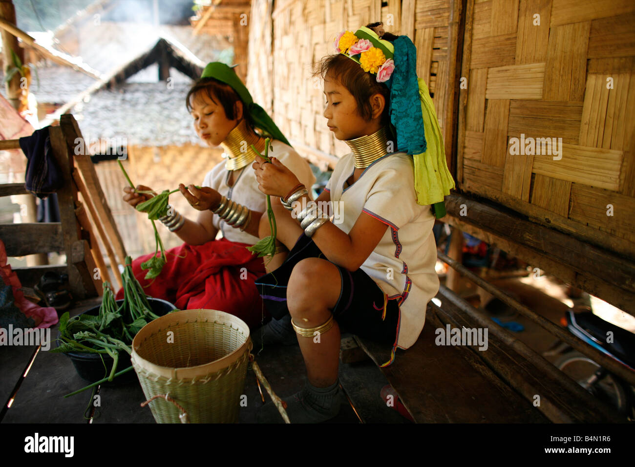 Giraffa ragazze di preparare il cibo per un pasto circa 300 profughi birmani in Thailandia sono membri del gruppo indigeno noto come Longnecks il più grande dei tre villaggi dove la Longnecks live è chiamato Nai Soi situato vicino a Mae Hong Son City Longnecks usura degli anelli di metallo sul loro collo che spingono la clavicola verso il basso e si estendono il collo sono una attrazione turistica turisti visitano Nai Soi per scattare foto di Longnecks e comprare il loro artigianato i villaggi sono criticati dalle organizzazioni per i diritti umani come umana giardini zoologici Foto Stock