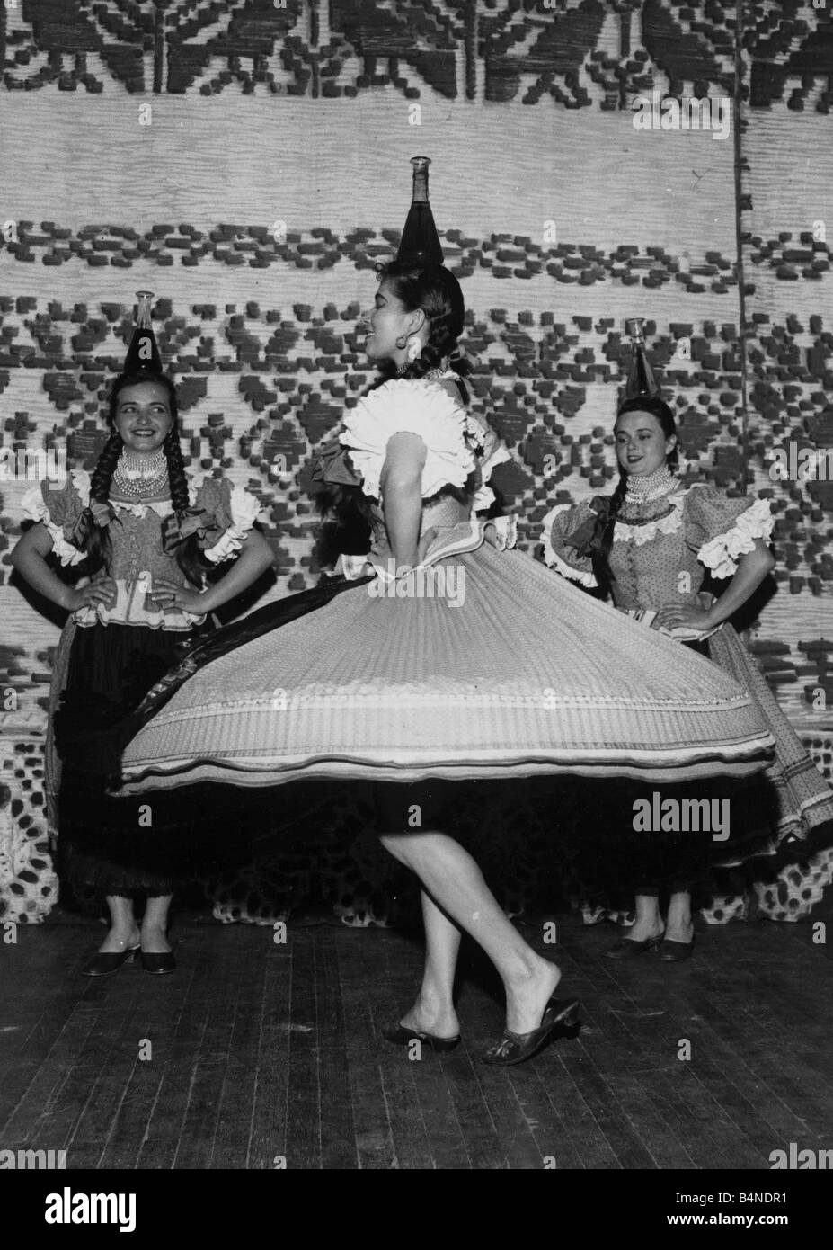 La ballerina Elizabeth varga saldi con calma un flagon di vino sulla sua testa come lei le danze di un tradizionale danza popolare ungherese il gruppo di ballerini sono di prendere parte ad un festival della canzone folk e musica a Londra s Palace Theatre Giugno 1956 Foto Stock