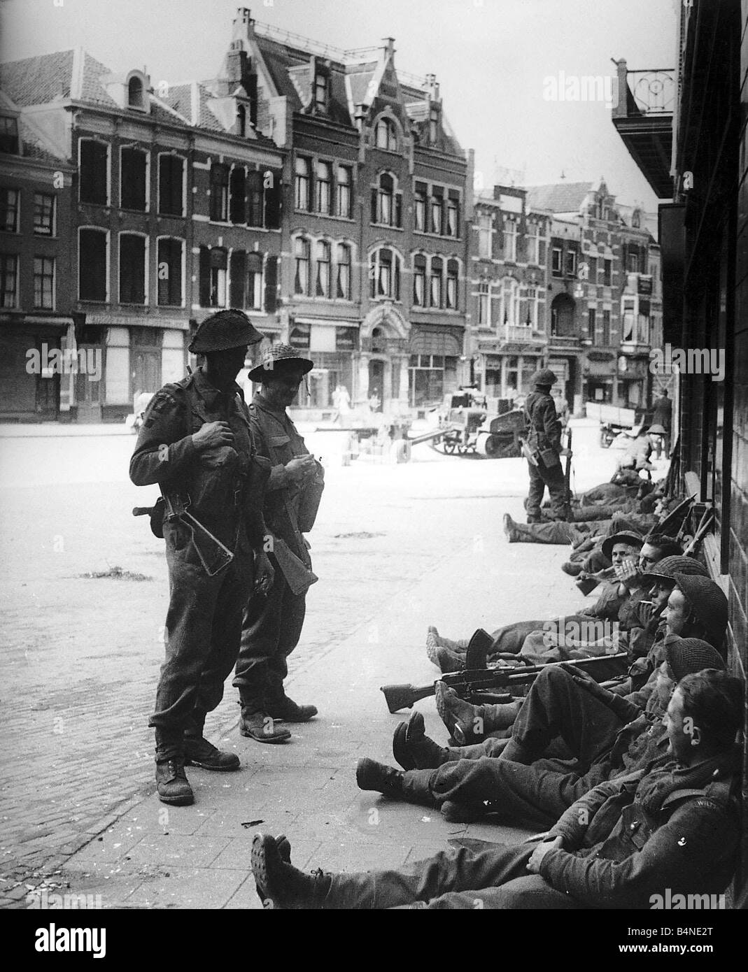 British soldati di fanteria prendere un periodo di riposo in strade di Nijmegen dopo la liberazione della città WW2 1944 Foto Stock