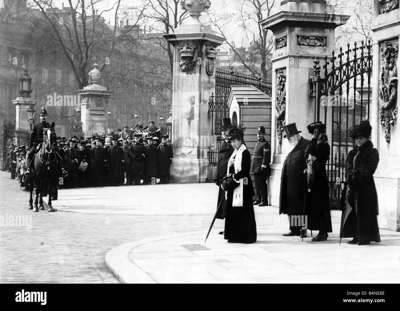 La Prima guerra mondiale la Regina Alexandra sorge al di fuori dei cancelli di Buckingham Palace per ricevere salutate da un marchpast delle truppe 1919 Foto Stock