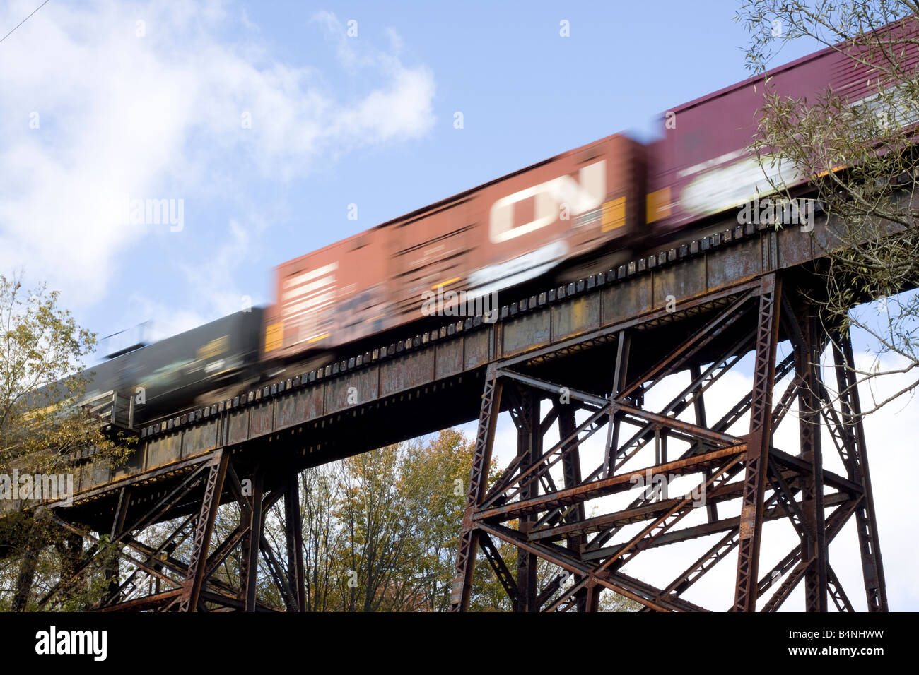 Un treno merci passa sopra un ponte stile di trave a traliccio Ninevah, NY. Foto Stock