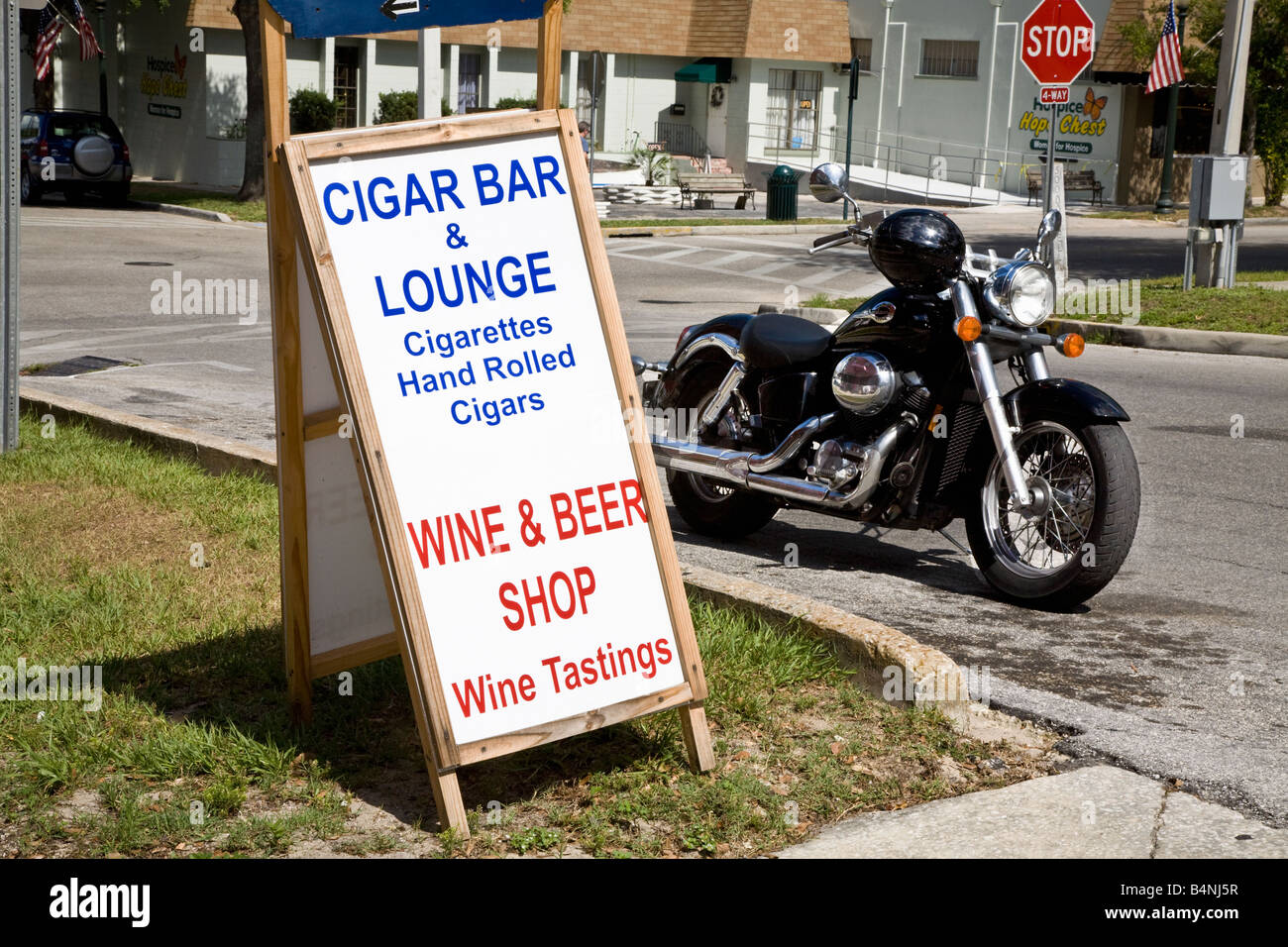 Motocicletta mediante un cigar bar segno nel piccolo centro America Foto Stock