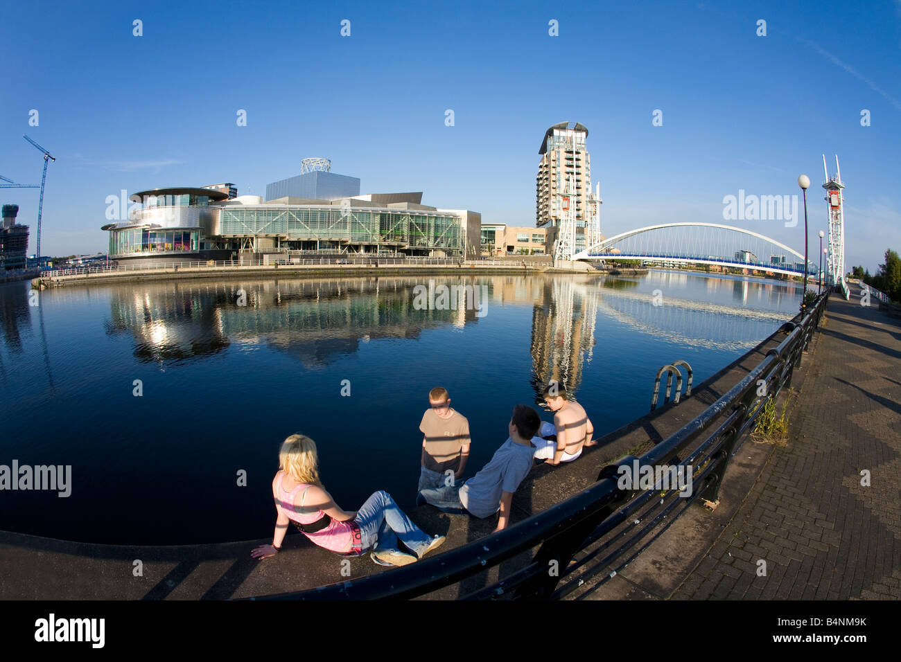 Quattro giovani adolescenti vicino al Millennium Bridge oltre il Manchester Ship Canal e Lowry Art Center Salford Quays, Manchester Foto Stock