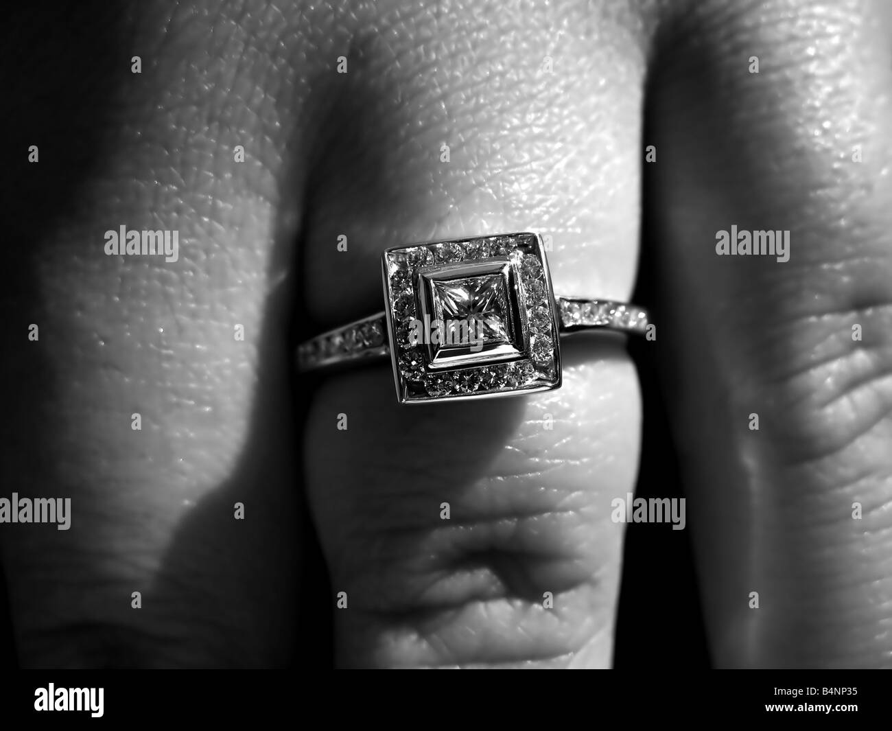 Primo piano dettaglio di un custom made princess taglio del diamante anello di fidanzamento Foto Stock