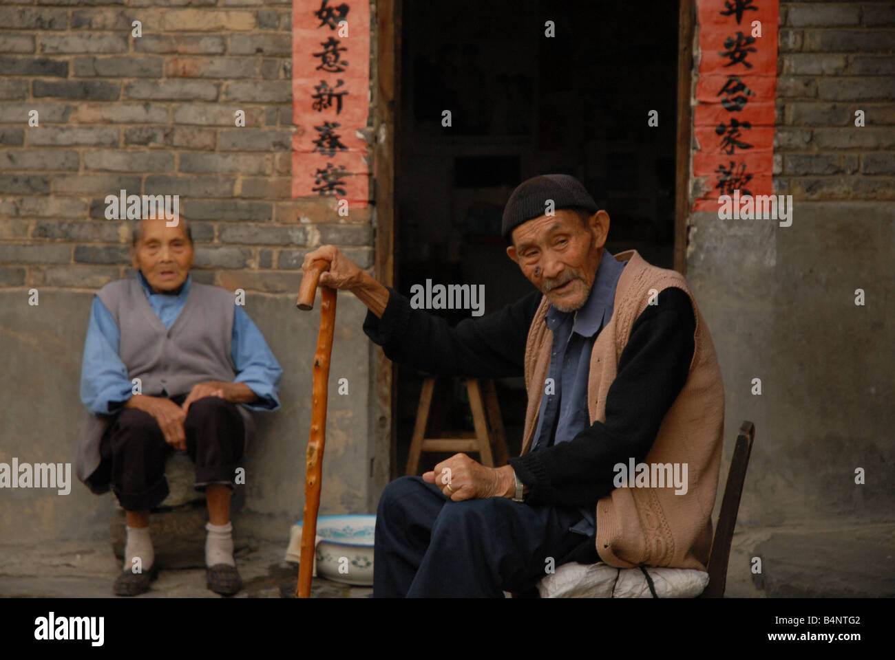 Un anziano giovane rilassarvi nel cortile di casa loro nelle zone rurali di Guizhou Provine, Cina. Foto Stock