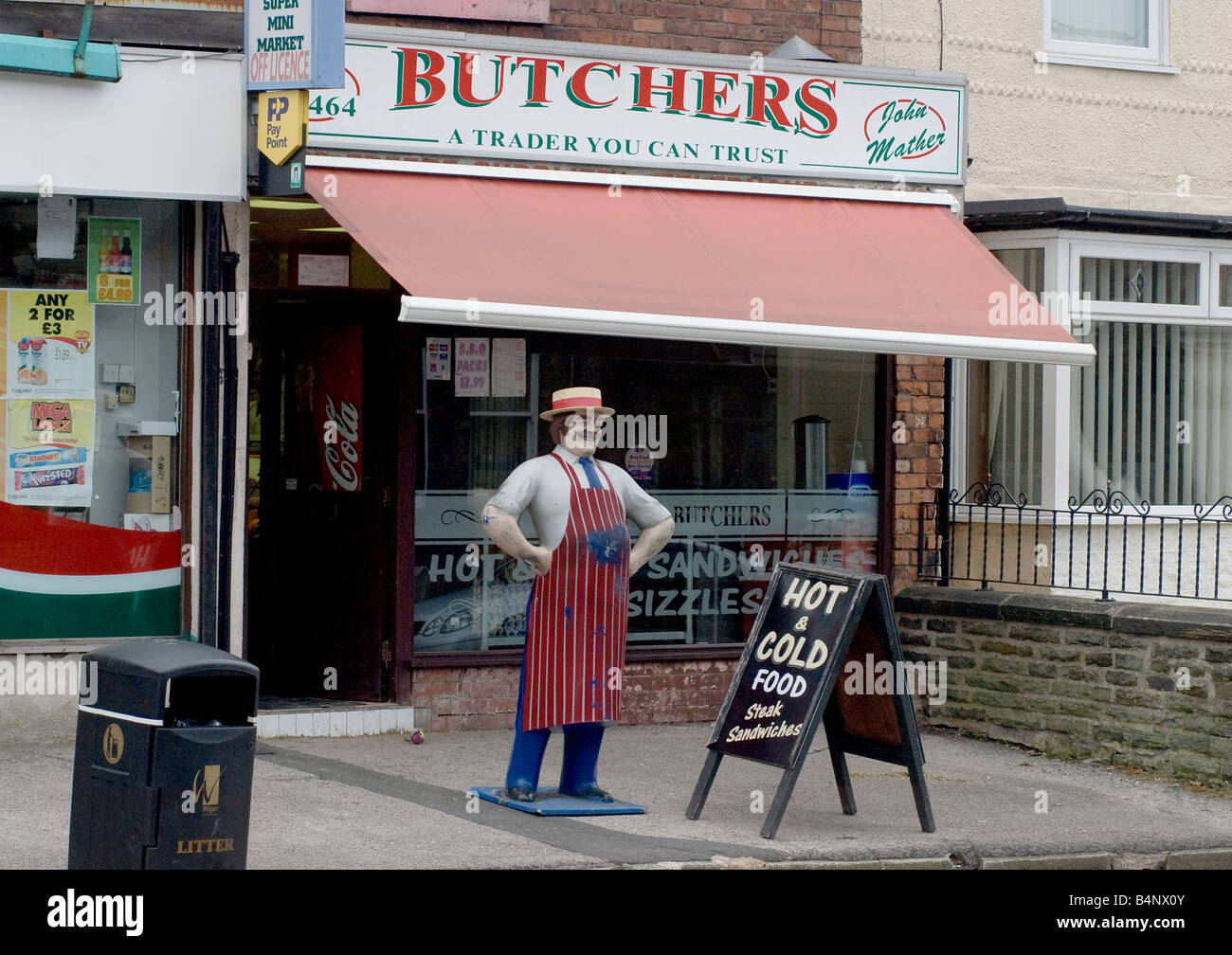 Il shopfront di una macelleria con una statua di un macellaio in Inghilterra. Foto Stock