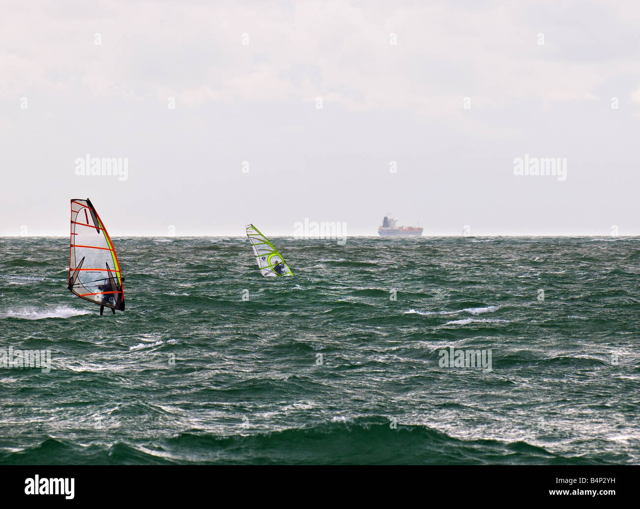Due windsurf nel Solent con spedizioni in lontananza. Foto Stock