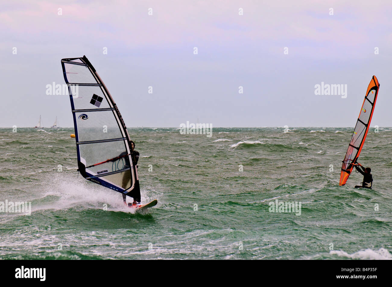 Due windsurf nel Solent in una fredda giornata. Foto Stock