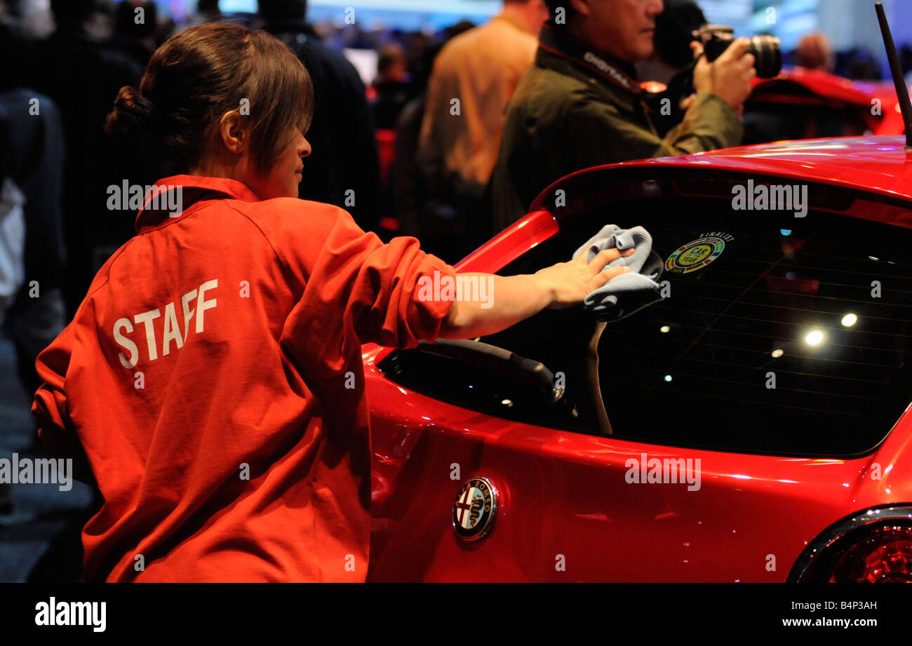 Un membro del personale pulizia su vetture Alfa Romeo stand durante il Paris International Motor Show. Foto Stock