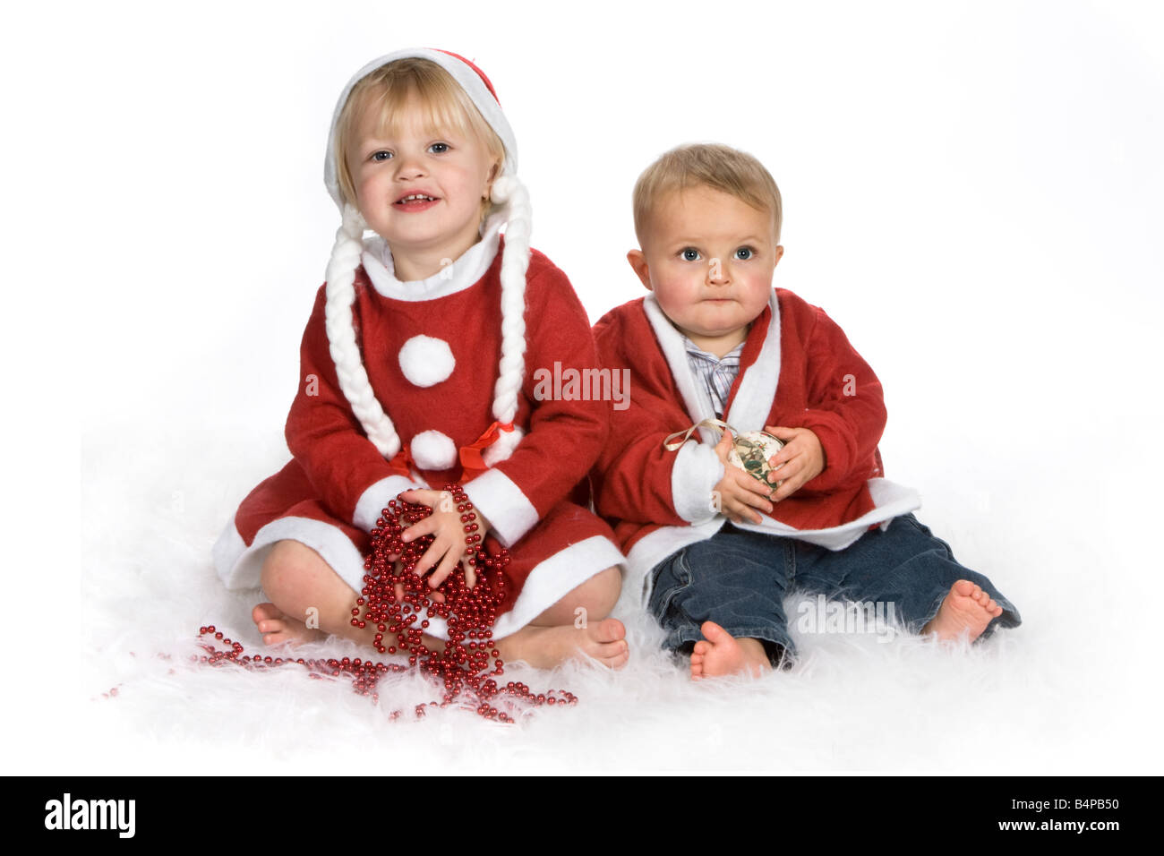 Ragazza bionda e suo fratello bambino vestito in abiti di Santa Foto Stock