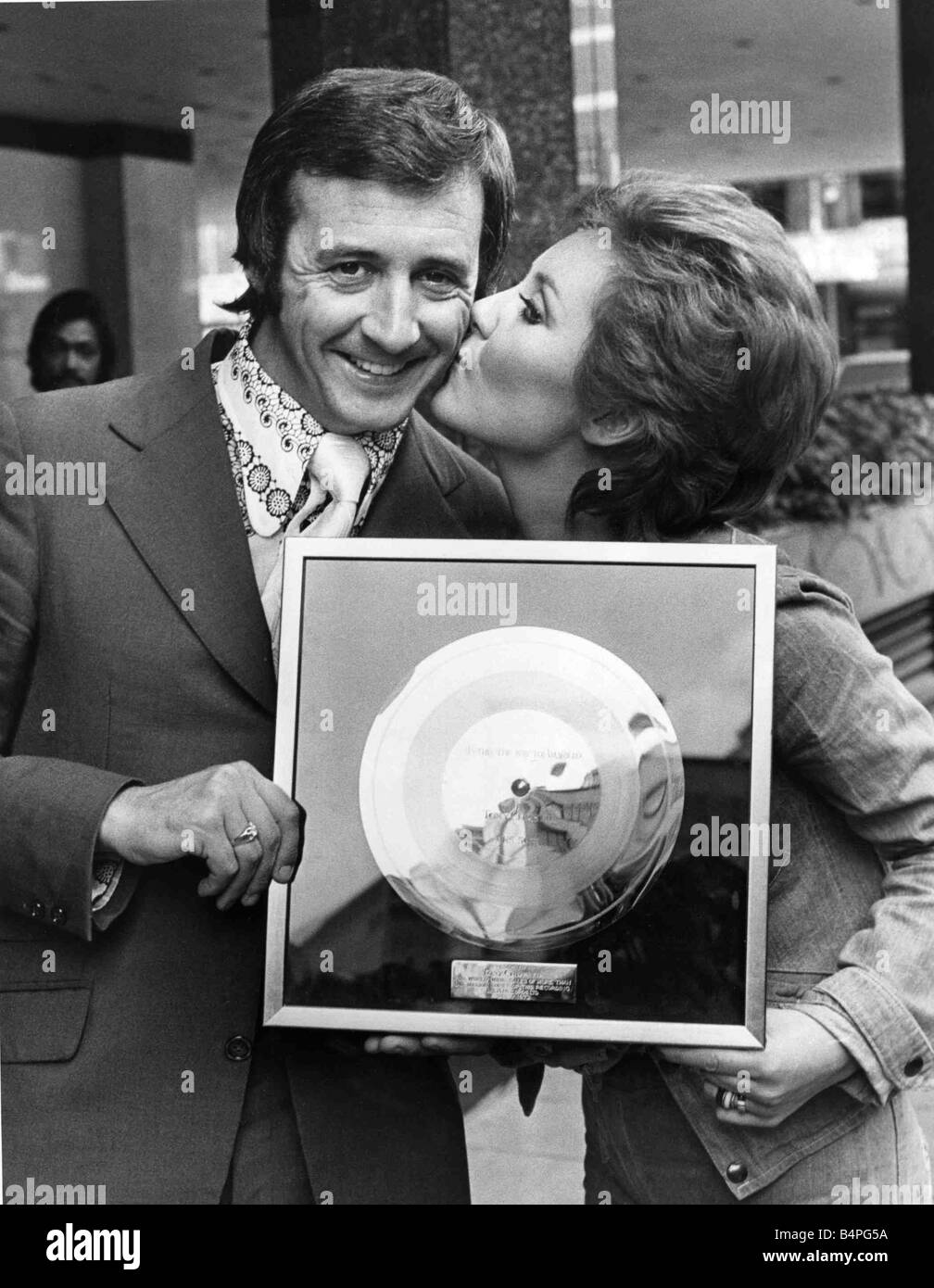 Il cantante Tony Christie riceve un bacio da Lulu che lo ha presentato con il suo disco d oro a Londra oggi per un milione di vendite a livello mondiale di Amarillo che era il numero 1 in un certo numero di paesi europei Agosto 1972 Foto Stock