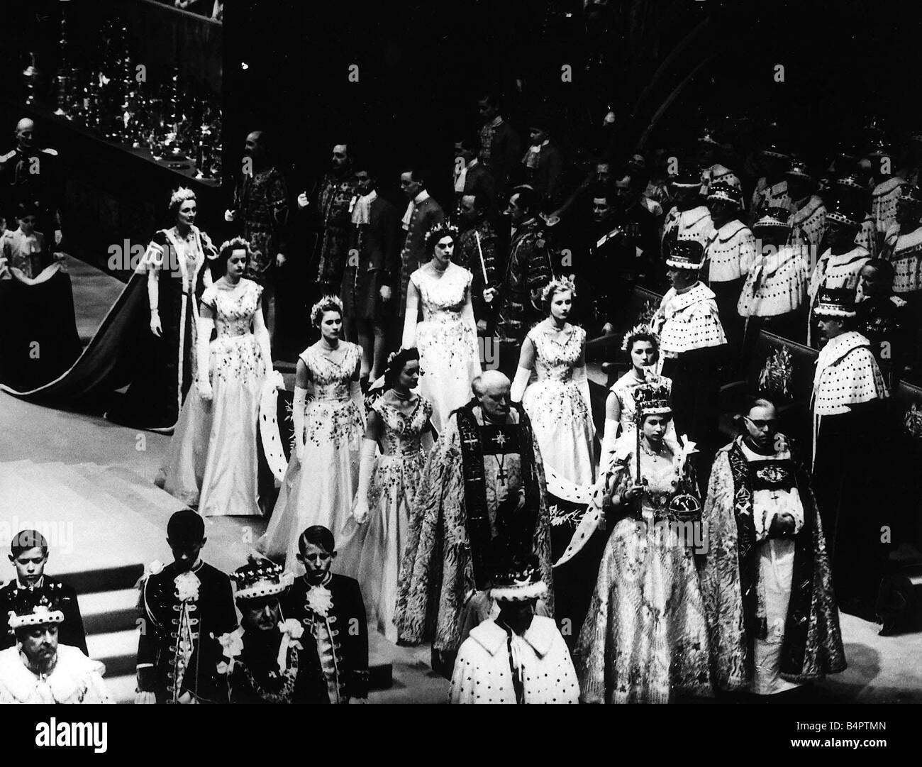 Queen Elizabeth II incoronazione a Westminster Abbey indossando la corona imperiale e portante lo scettro e Orb è frequentato dal suo cameriere di onore come lei lasciare l'Abbazia Foto Stock