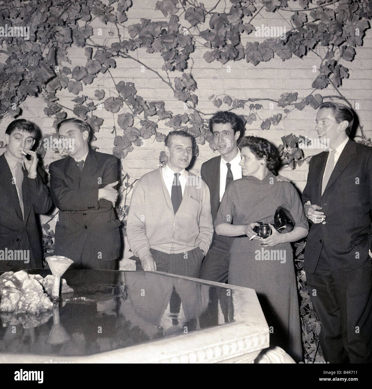 Kenneth Tynan a un libro parte estrema destra guardando alla sua sinistra, Ottobre 1957 Foto Stock