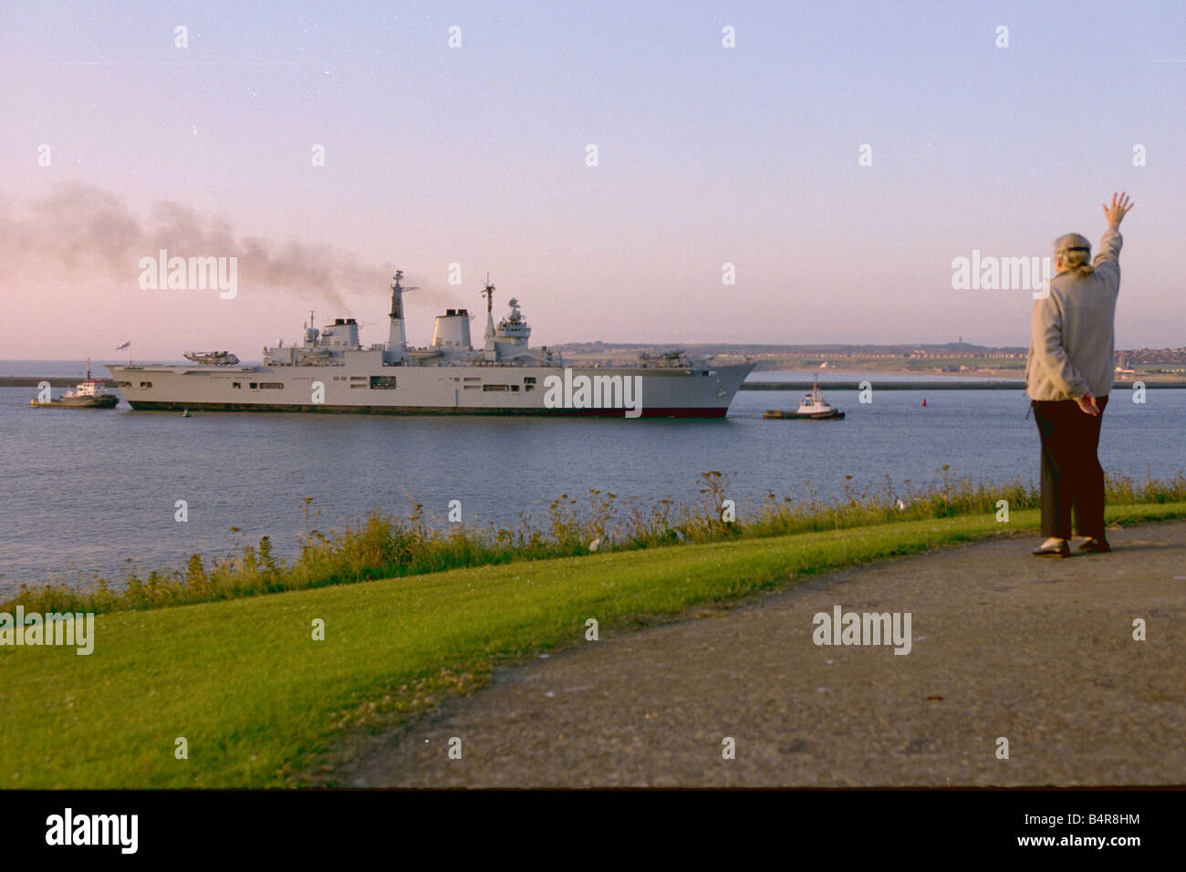 Un lone spettatore saluta HMS Invincible come lei arriva sul fiume Tyne 20 07 00 Foto Stock