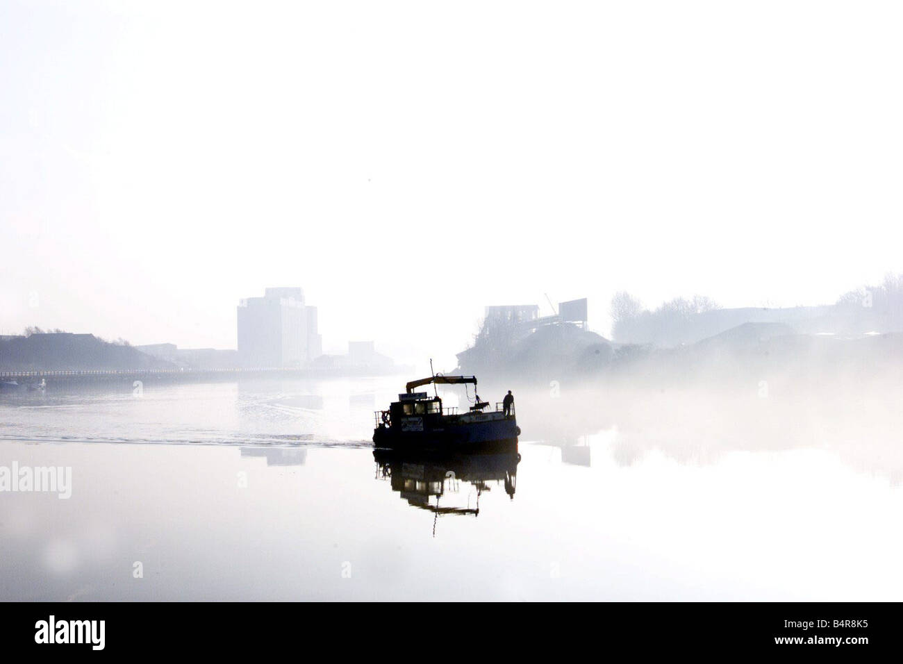 Una piccola barca rendendo il suo passato modo St Peter s Basin Newcastle in una nebbiosa mattina sul fiume Tyne 25 02 03 Foto Stock