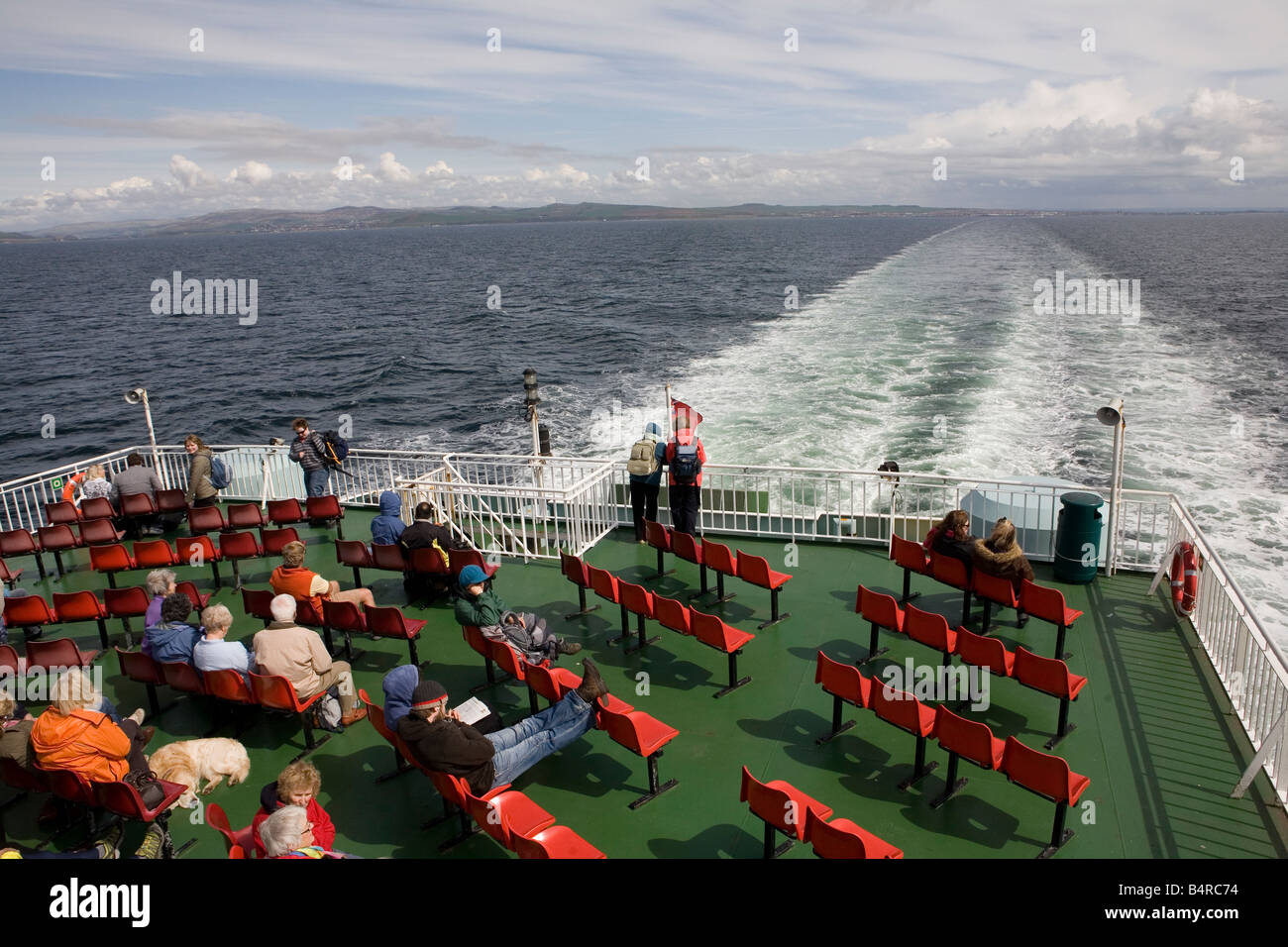 Passeggeri del traghetto da Ardrossan per l'isola di Arran nelle acque ad ovest della Scozia guardando indietro verso la terraferma Foto Stock