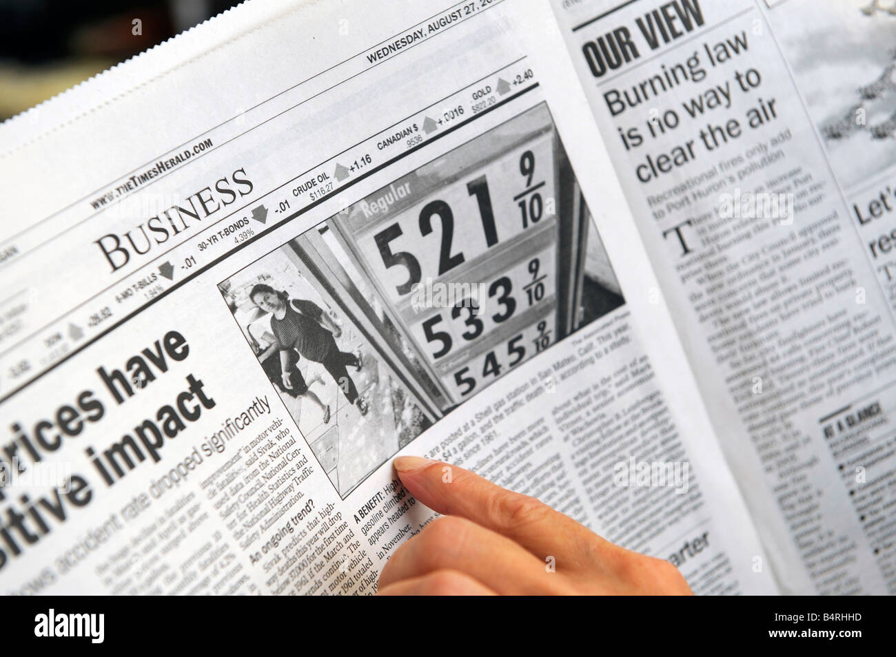 Femmina adulta legge circa il prezzo elevato del gas in un giornale Foto Stock