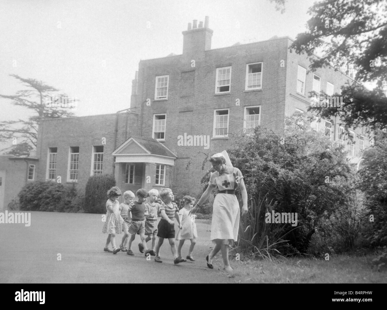 Un infermiere takses alcuni bambini per una passeggiata per i motivi del Beech Hill House Casa di Convalescenza di Ottobre 1958 Foto Stock