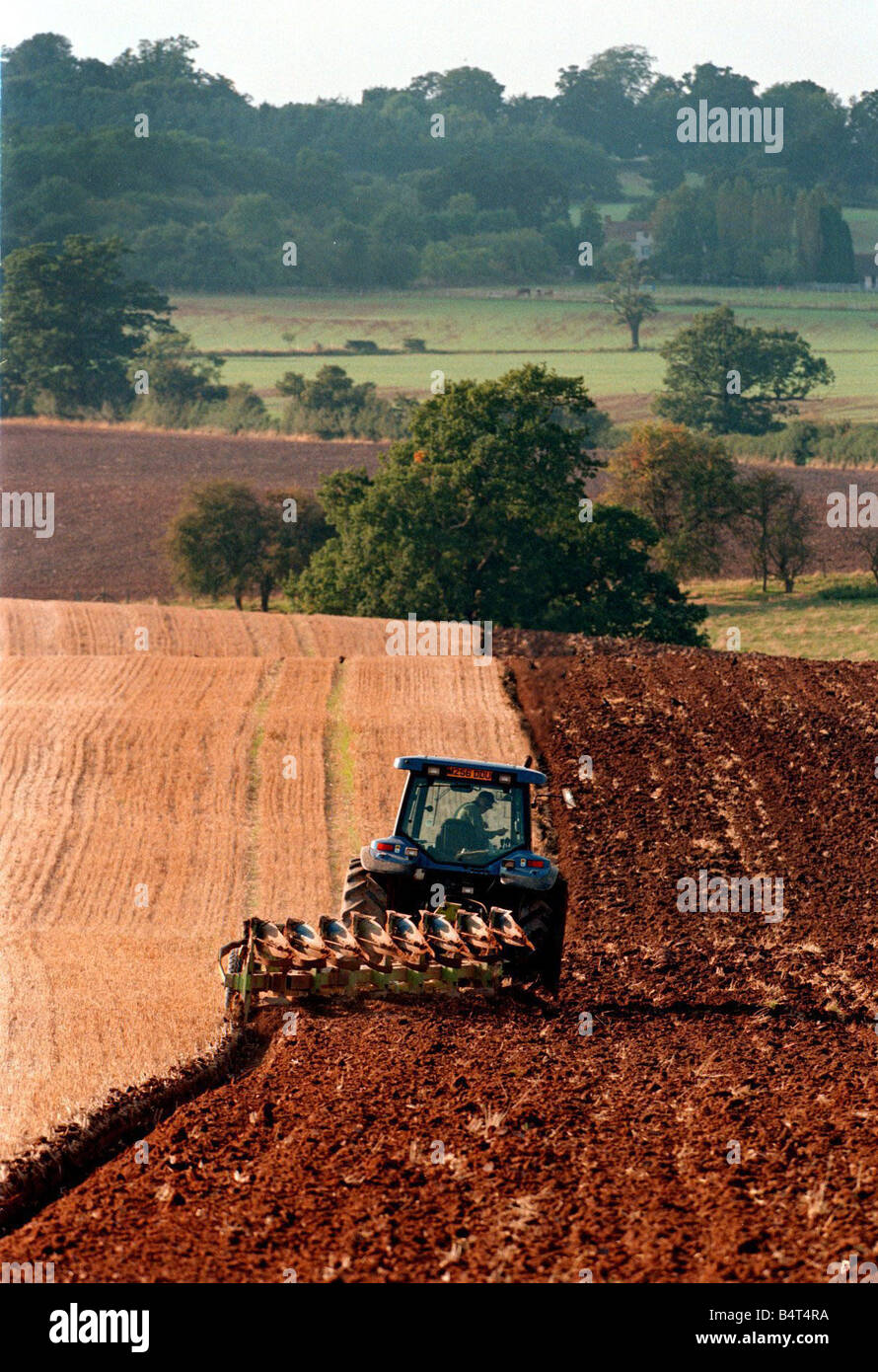 Lavoratore agricolo interessato non sterza il trattore e aratro in prima serata la luce sul terreno sul Ragley tenuta vicino a Alcester Warwickshire 1998 Foto Stock