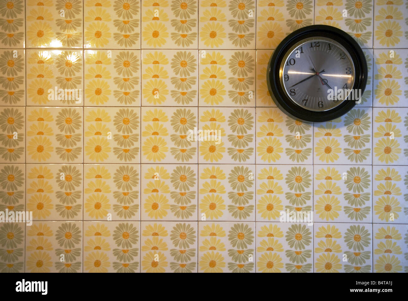 Un orologio si blocca da solo su un fiore parete piastrellata da anni  sessanta in cucina Foto stock - Alamy
