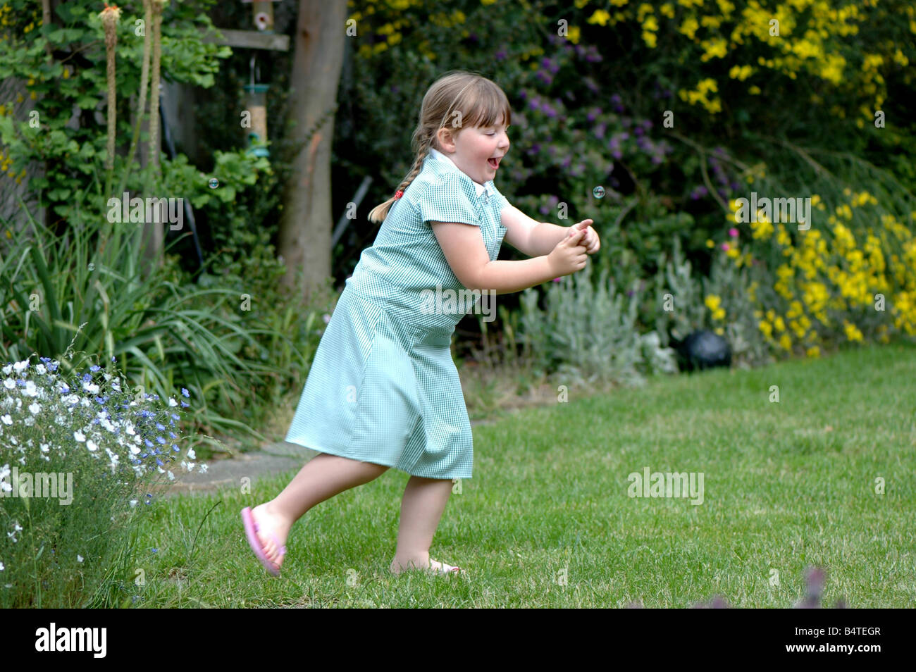 Una giovane ragazza a caccia di bolle Foto Stock