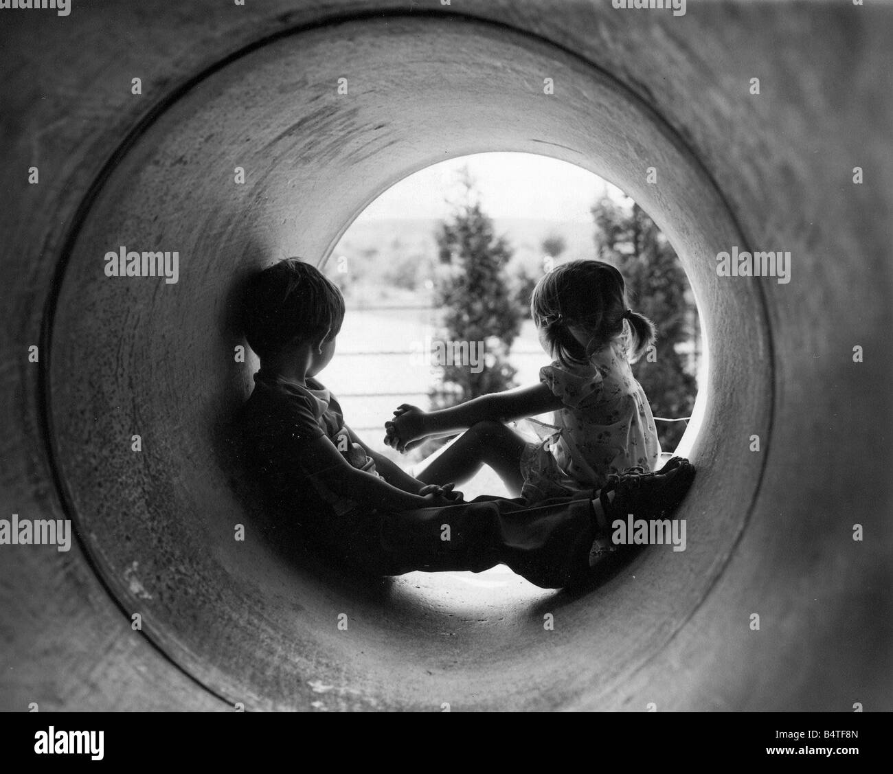 Nicola Jackson e Giuseppe Devin hanno trovato il posto ideale per guardare il mondo che passa da un gigantesco tubo in calcestruzzo a Willow vivaio Foto Stock