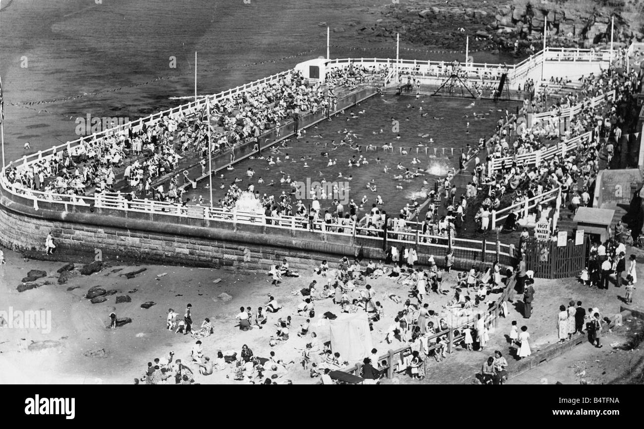 Schiere di adoratori del sole godendo il sole splendente a Tynemouth Foto Stock