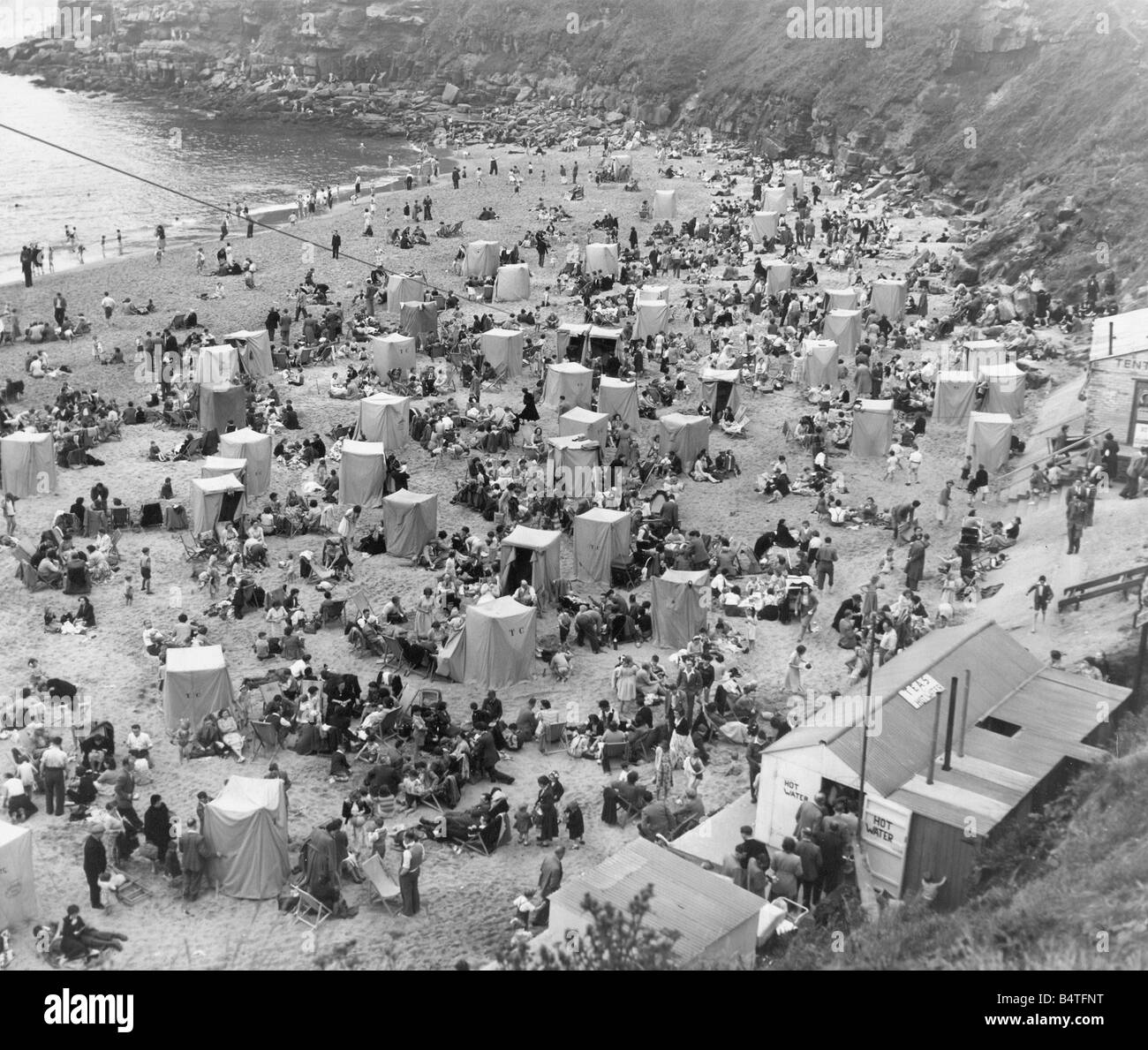 Schiere di adoratori del sole godendo il sole splendente a Tynemouth Foto Stock