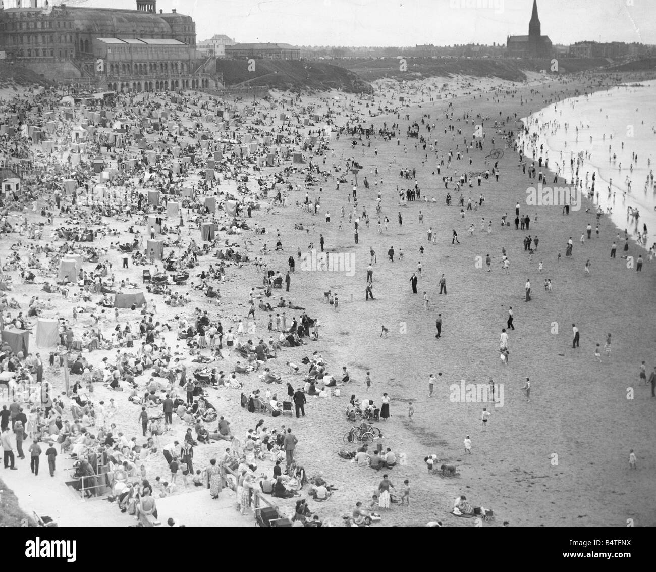 Schiere di adoratori del sole godendo il sole splendente a Tynemouth Foto Stock