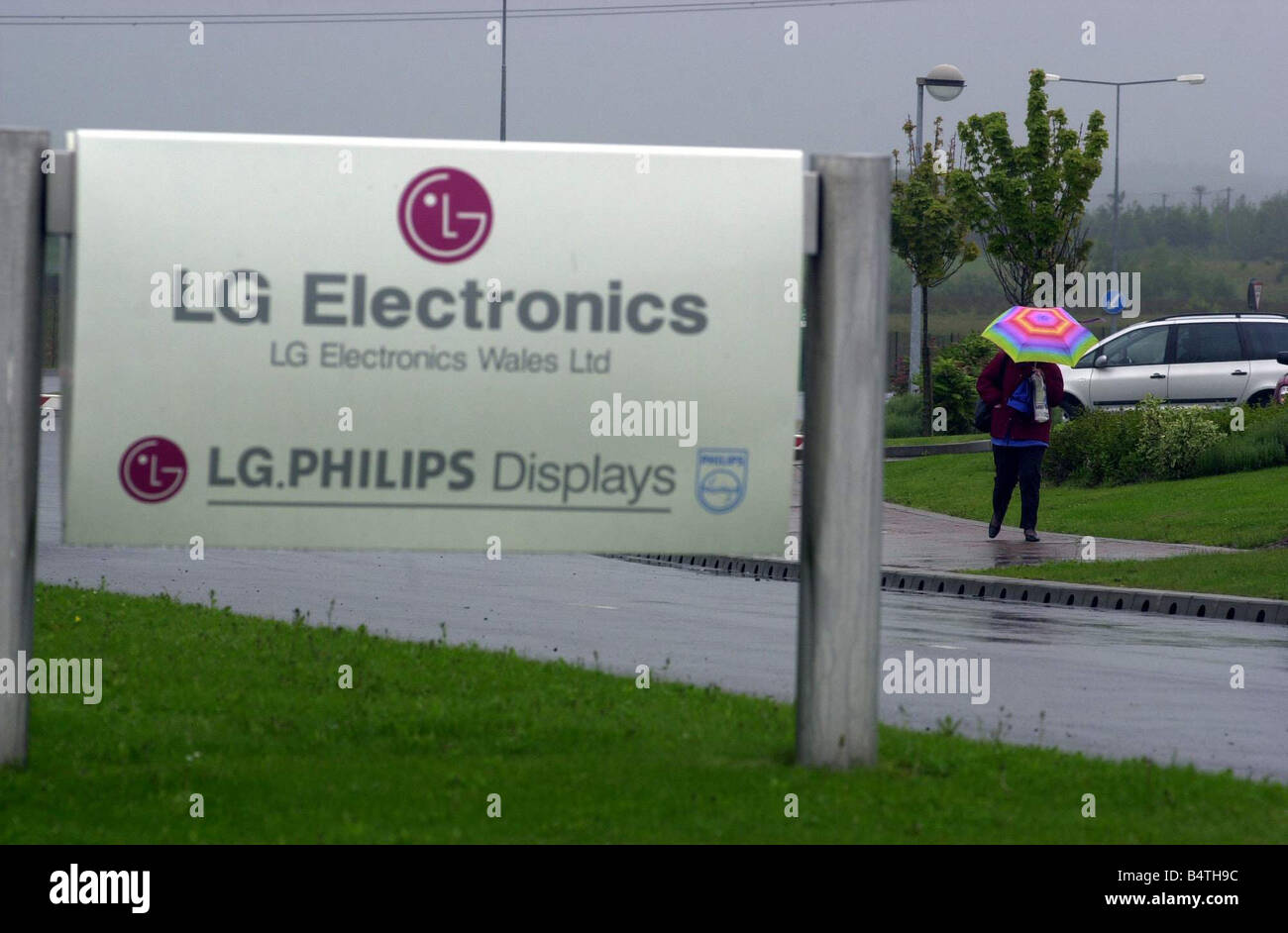 Triste fine nella guida sotto la pioggia di un lavoratore lascia la LG Phillips visualizza la fabbrica al di fuori di Newport dove centinaia di lavoratori perderanno il loro posto di lavoro 22 Maggio 2003 Foto Stock