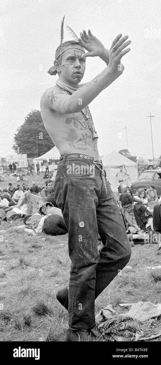 Flower Power festival a Woburn Abbey Agosto 1967 Un hippy vestito con le piume in una banda di testa a guardare come un indiano rosso fa un Foto Stock