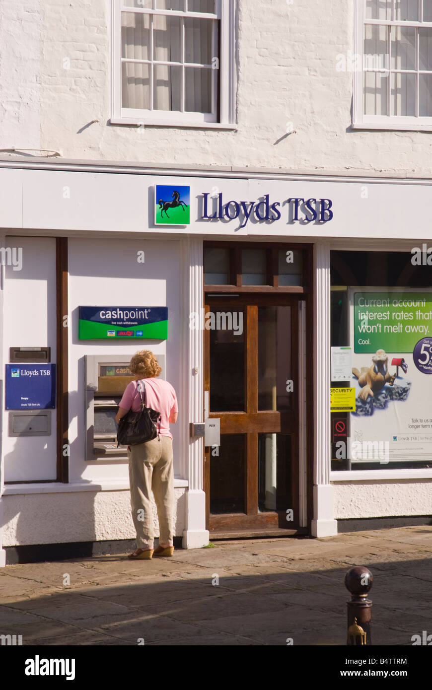 Donna di mezza età prelievo contanti da bancomat al di fuori del Lloyds TSB Bank in Bungay, Suffolk, Regno Unito Foto Stock