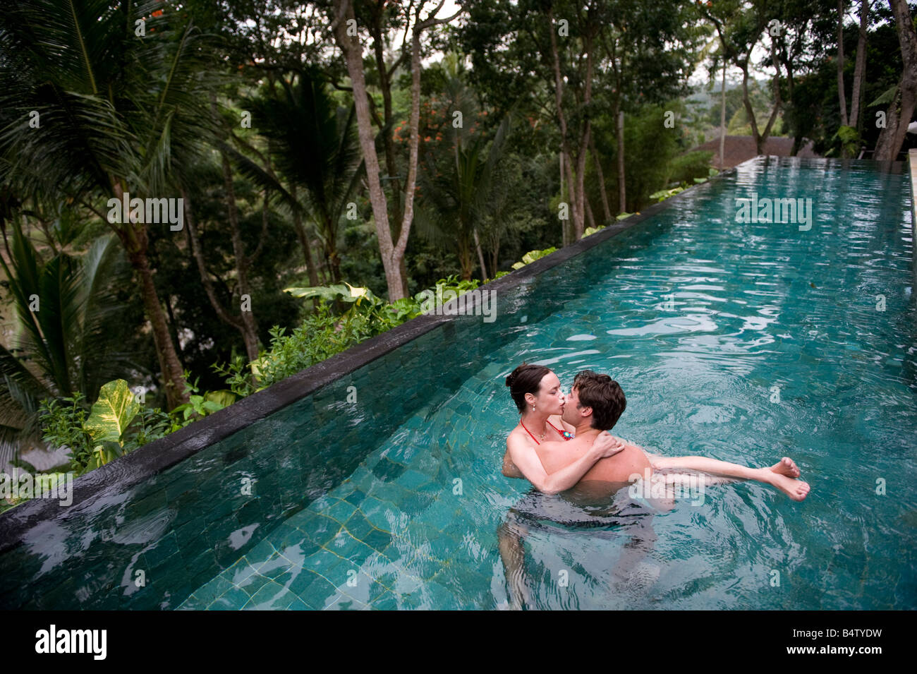 Un giovane gode di una nuotata insieme mentre si abbracciano. Foto Stock